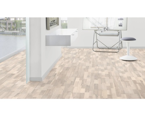 Světlá místnost s dřevěnou podlahou ve vzoru rybí kosti, psací stůl a stolička