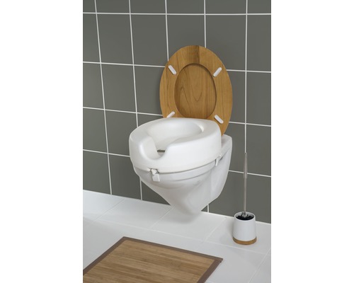 Zvýšená toaleta s dřevěným víkem a WC kartáčem v koupelně