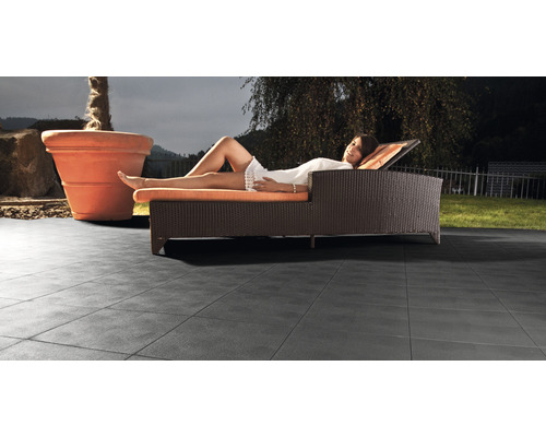 Terasa s dlaždicemi, lehátkem a květináčem na zahradě