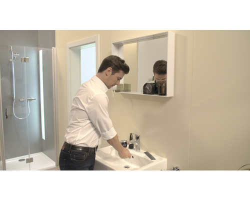 Moderní koupelna s umyvadlem, zrcadlem a sprchou.