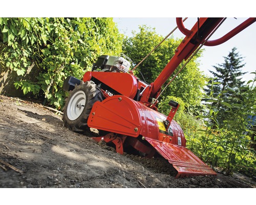 Motorový kultivátor při zpracování půdy na zahradě.