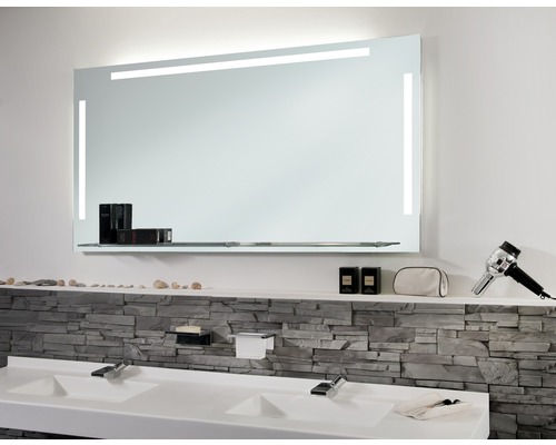 Koupelna s osvětleným zrcadlem a dvojitým umyvadlem.