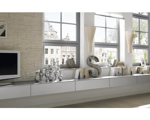 Světlý obývací pokoj s bílým nábytkem, dekoracemi a velkými okny.