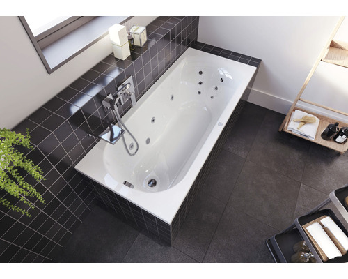 Vestavěná vana s funkcí vířivky, armaturou a obklady v koupelně.