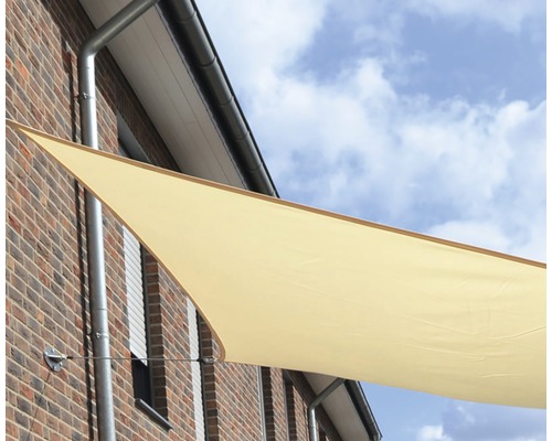 Trojúhelníková sluneční plachta upevněná na stěně domu