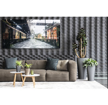 Obývací pokoj s pohovkou, konferenčními stolky, hrnkovými rostlinami a zarámovaným obrázkem vlakových vozů