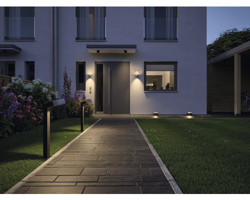 Osvětlená zahradní cesta k modernímu domu s venkovním osvětlením
