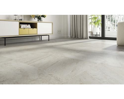 Světlá místnost s položenou dlažbou, příborníkem a oknem.