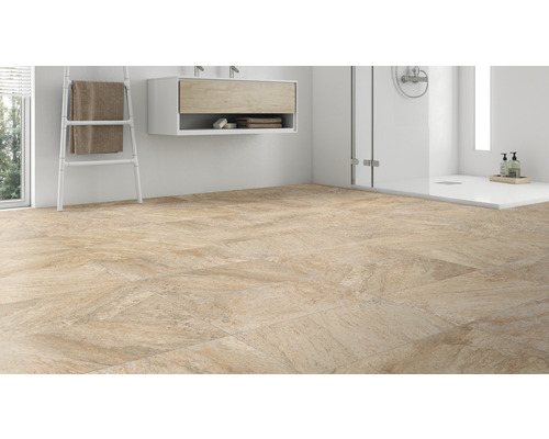 Koupelna s dlažbou, umyvadlem a sprchou.