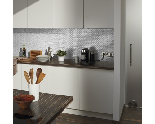 Moderní kuchyně s bílými skříňkami, mozaikovými obklady a dřevěnou pracovní deskou