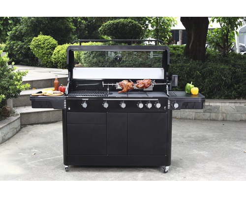 Velký gril s funkcí otočného rožně, grilované jídlo a odkládací plochy ve venkovním prostředí