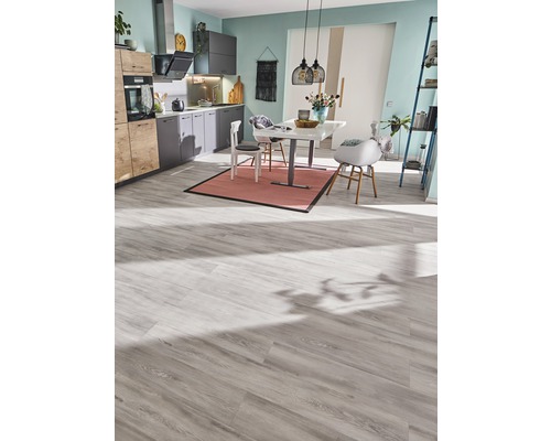 Světlá kuchyně s jídelním stolem, židlemi a laminátovou podlahou.