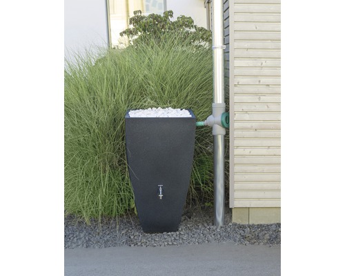 Nádrž na dešťovou vodu s výplňovým materiálem vedle svodu na domě