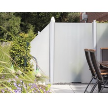 Zahradní scéna se zástěnou, stolem a židlemi na terase.