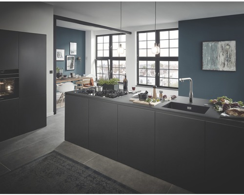 Světlá, prostorná kuchyně s kuchyňským ostrovem, dřezem a jídelním koutem v pozadí.