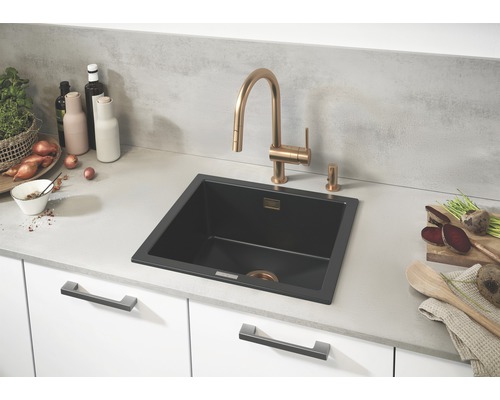 Kuchyňská scéna s černým dřezem a vodovodní baterií