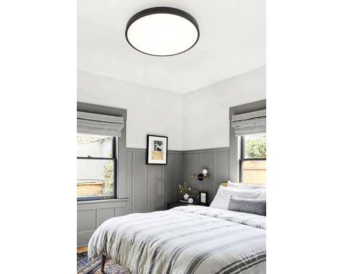 Ložnice s kulatým stropním svítidlem a dvoulůžkem