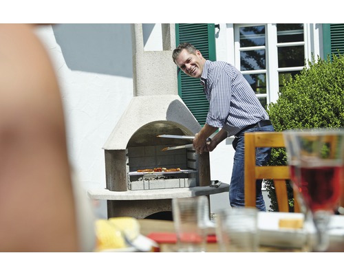 Muž griluje jídlo venku s zahradním grilem