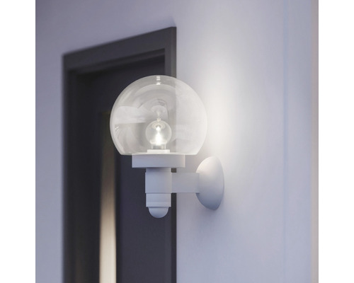 Nástěnné svítidlo s kulatou skleněnou koulí ve světlé místnosti vedle dveří