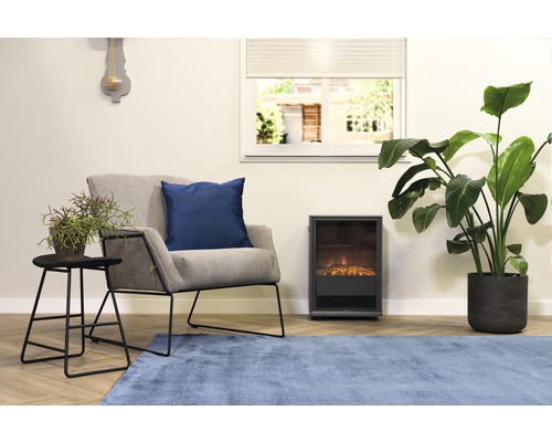 Obývací pokoj s křeslem, polštářem, stolem, pokojovými rostlinami, elektrickým krbem a kobercem