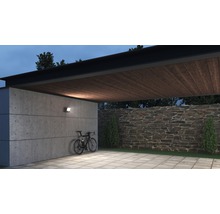 Osvětlená garáž s betonovou stěnou, stropem z dřevěných trámů a jízdním kolem