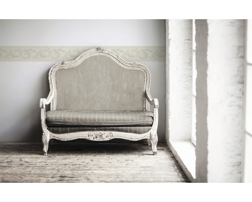 Dekorativní pohovka s květinovým okrajem na zdi pro elegantní atmosféru v místnosti.