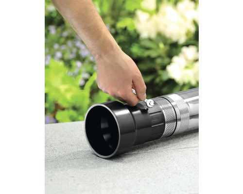 Osoba připevňuje trubku ke hlubinnému čerpadlu pomocí klíče.