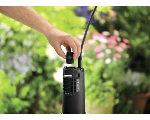 Ruka upevňuje konektor na zahradní čerpadlo Gardena.