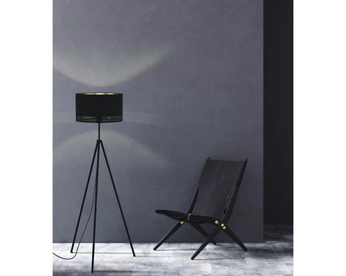 Stojací lampa a dřevěná židle před stěnou