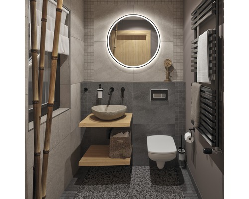 Moderní koupelna s kamennými obklady, umyvadlo s umyvadlovou mísou z přírodního kamene, kulaté zrcadlo s osvětlením a radiátor na ručníky.