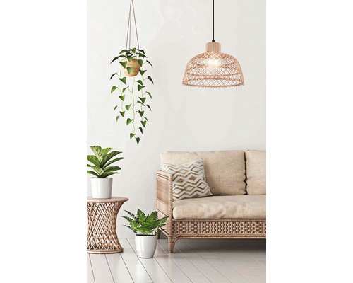 Obývací pokoj s ratanovou pohovkou, odkládacím stolkem, závěsnou lampou a pokojovými rostlinami