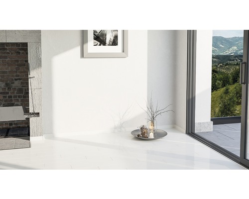 Světlá místnost s bílou dlažbou, zdivem a oknem do přírody