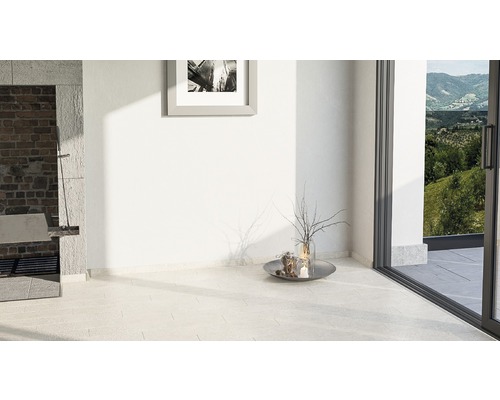 Světlá místnost s dlažbou, terasovými dveřmi a dekorací