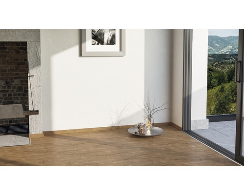 Světlá místnost s dřevěnou podlahou, dekorací a výhledem do zeleně