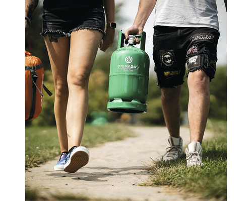 Lidé nesou láhev s grilovacím plynem Primagas a spací pytel na cestě.