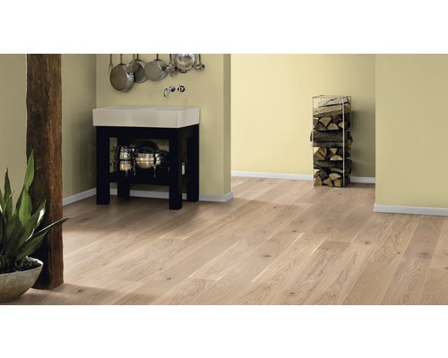 Světlá dřevěná podlaha v místnosti s umyvadlem, skladem dřeva a dekorací