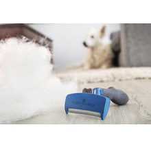 FURminator kartáč na zvířecí chlupy s psí srstí a psem v pozadí