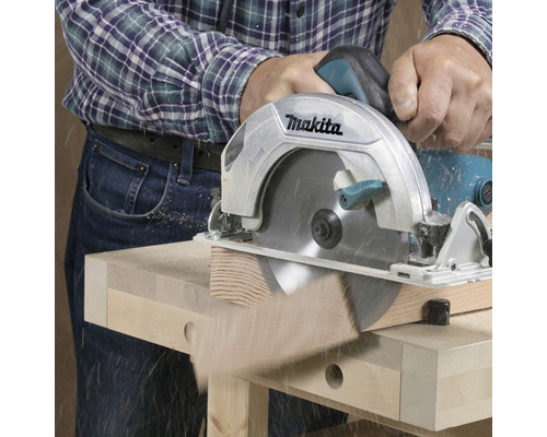 Kotoučová pila Makita řeže dřevo na pracovním stole.