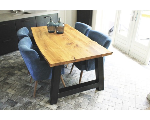 Jídelní stůl s dřevěnou deskou a černými nohami obklopený židlemi