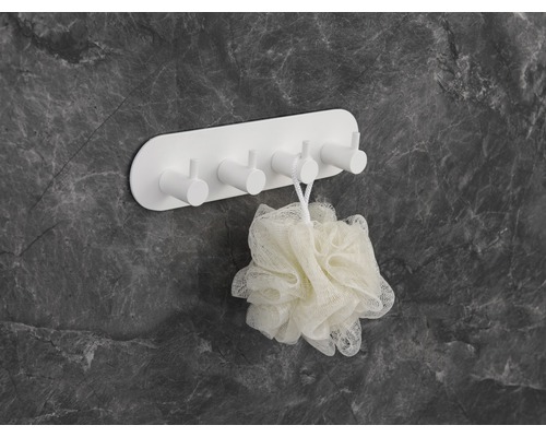 Bílý nástěnný hák s koupelovou houbou pro skladování v koupelně