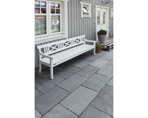 Exteriér s kamennou dlažbou a bílou zahradní lavicí před stěnou domu