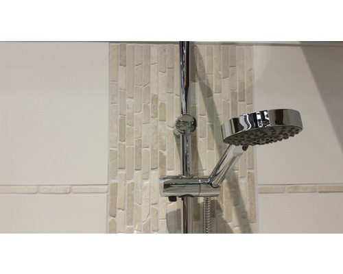 Sprchová tyč s ruční sprchou před koupelnovou stěnou