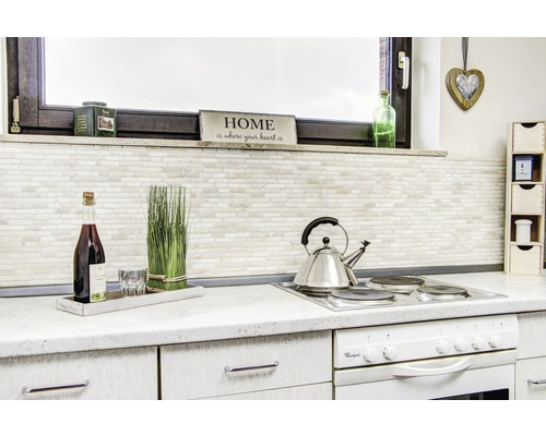 Kuchyňská scéna s varnou deskou, čajovou konvicí, dekoracemi a kuchyňským náčiním na pracovní desce.