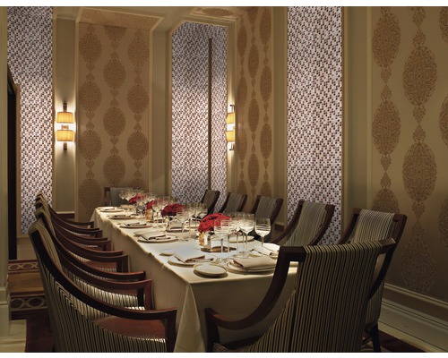 Elegantní jídelna s mozaikovou stěnou, zdobeným stěnovým panelem, prostřeným stolem a židlemi