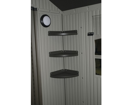 Vnitřní pohled na zahradní domek s rohovou policí a světlem