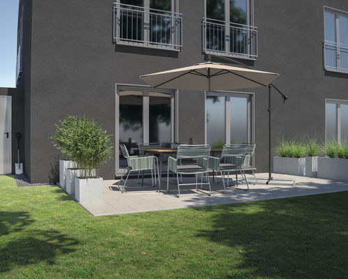 Terasa s jídelním stolem, židlemi, slunečníkem a truhlíky před rodinným domem.