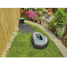 Robotická sekačka Gardena s nabíjecí stanicí na trávníku v zahradě