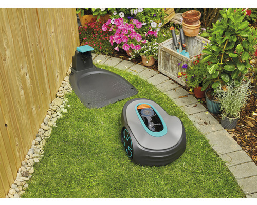 Robotická sekačka Gardena s nabíjecí stanicí na trávníku v zahradě