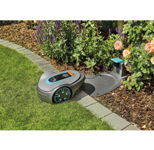 Robotická sekačka Gardena s nabíjecí stanicí na trávníku v zahradě