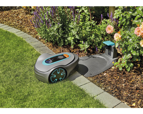Robotická sekačka Gardena s nabíjecí stanicí na trávníku v zahradě